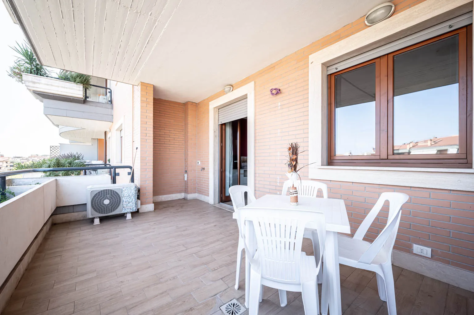 Balcone ampio con sedie bianche e tavolo apparecchiato per due