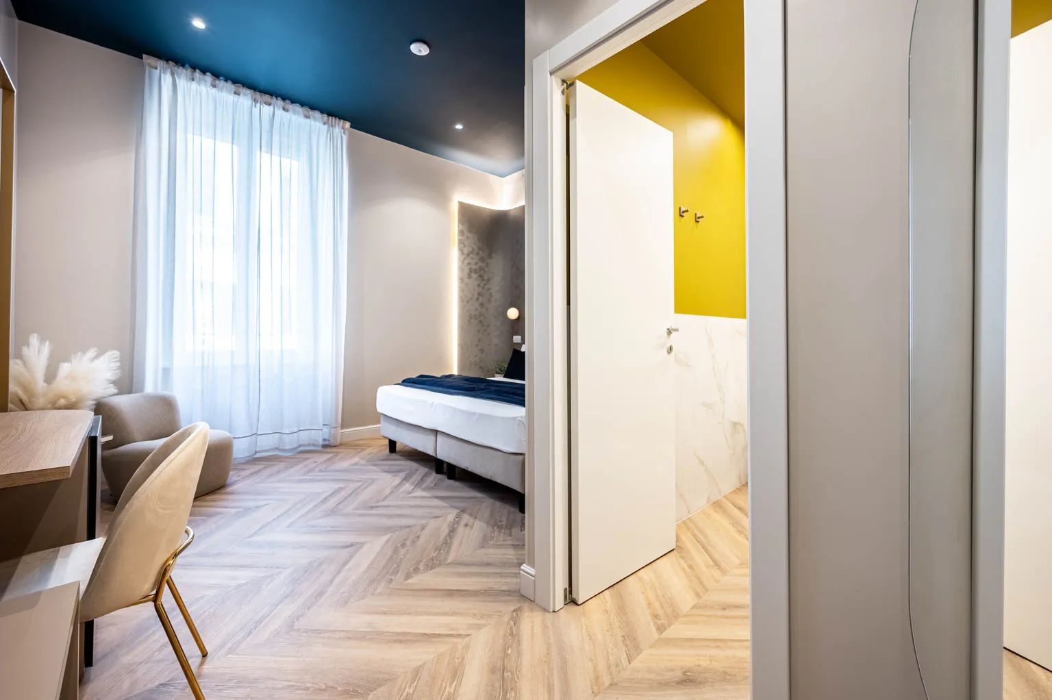 Stanza con parquet a spina, tende leggere e soffitto blu notte