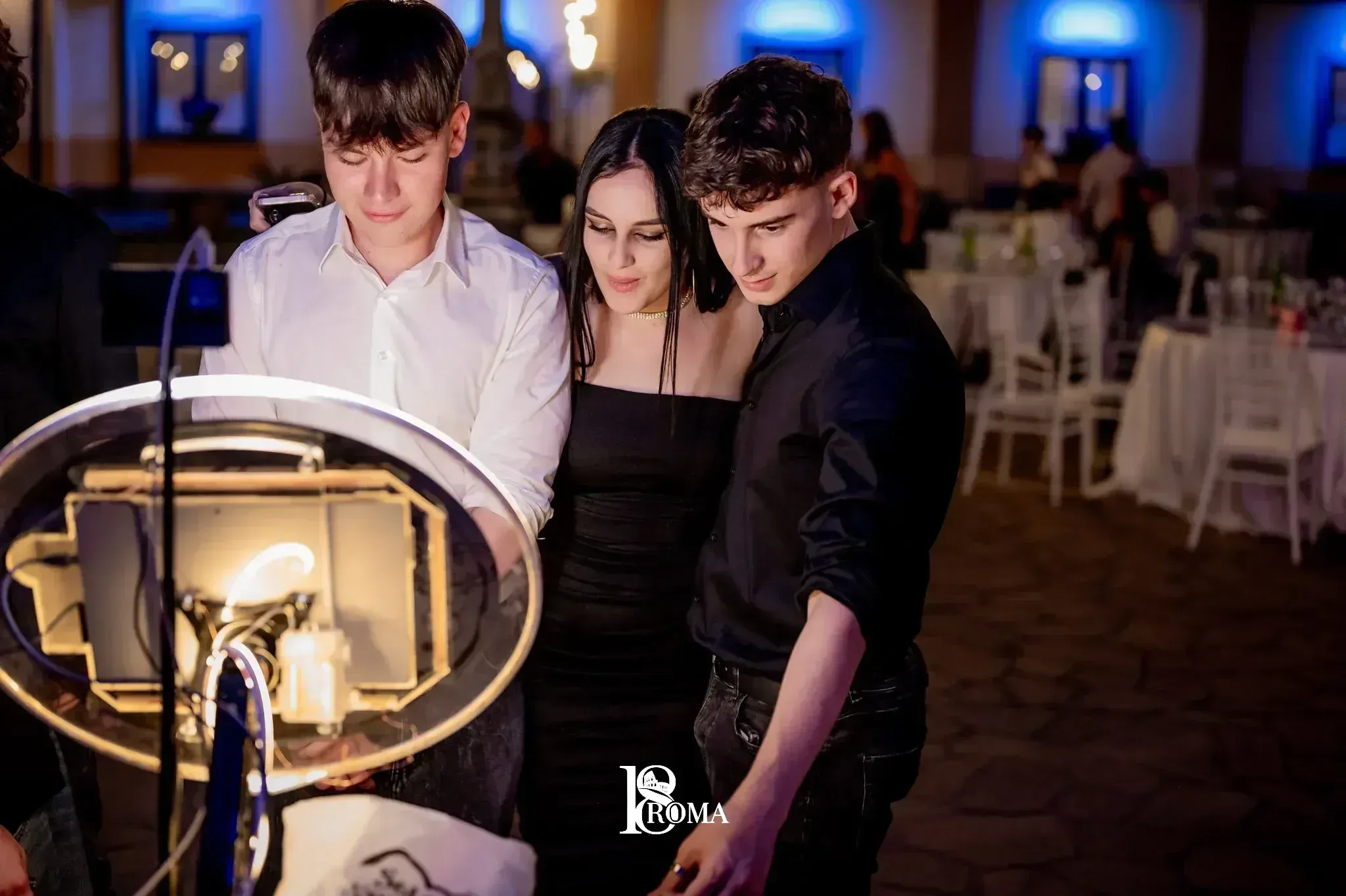 Tre ospiti davanti alla postazione photobooth con ring light in una sala per feste